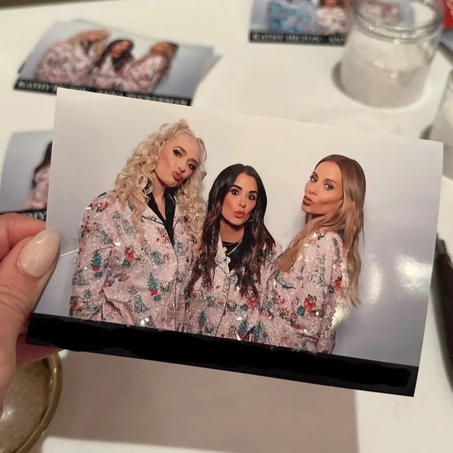 Photo of three women in matching floral robes, standing together and posing for the camera.