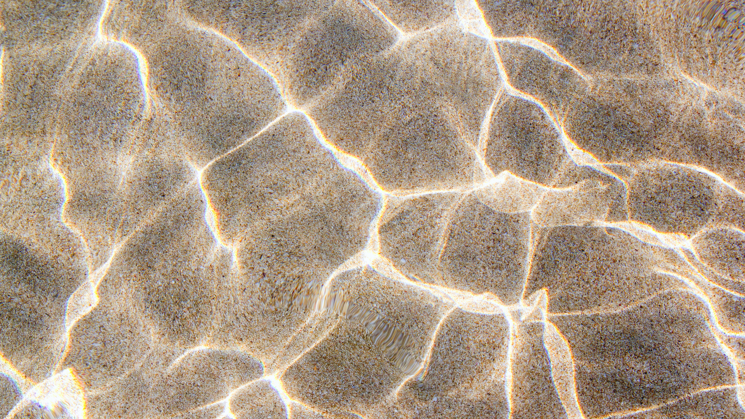 Sunlight rippling across the sand on a Miami beach.