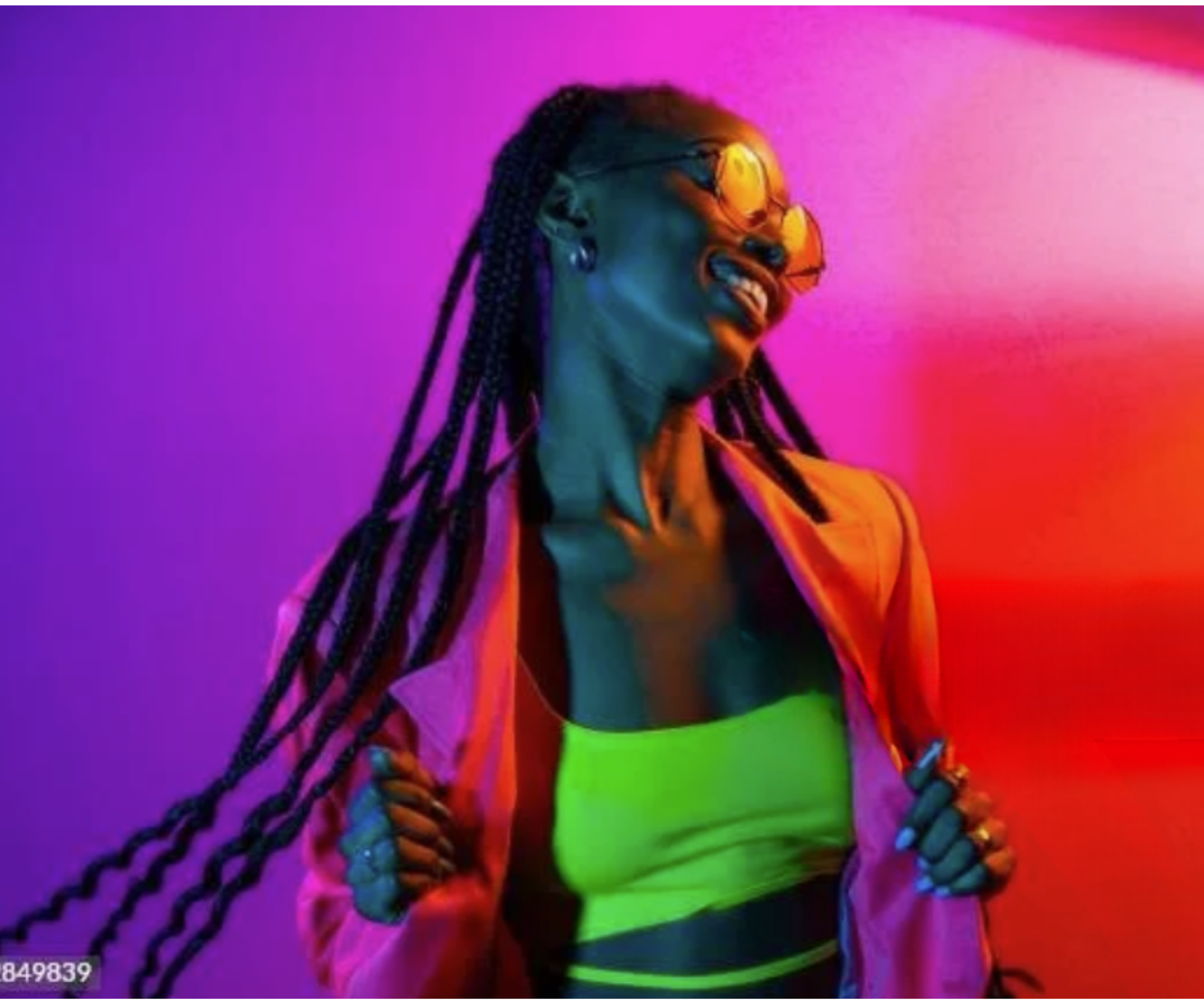 Woman with long braided hair wearing sunglasses, neon yellow and black clothing, and a pink jacket, posing against a colorful purple and pink background in vibrant lighting.