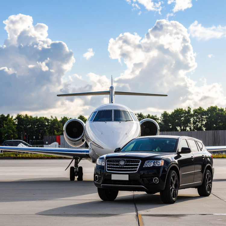 A black SUV parked on an airport tarmac with a private jet airplane in the background, under a partly cloudy sky.