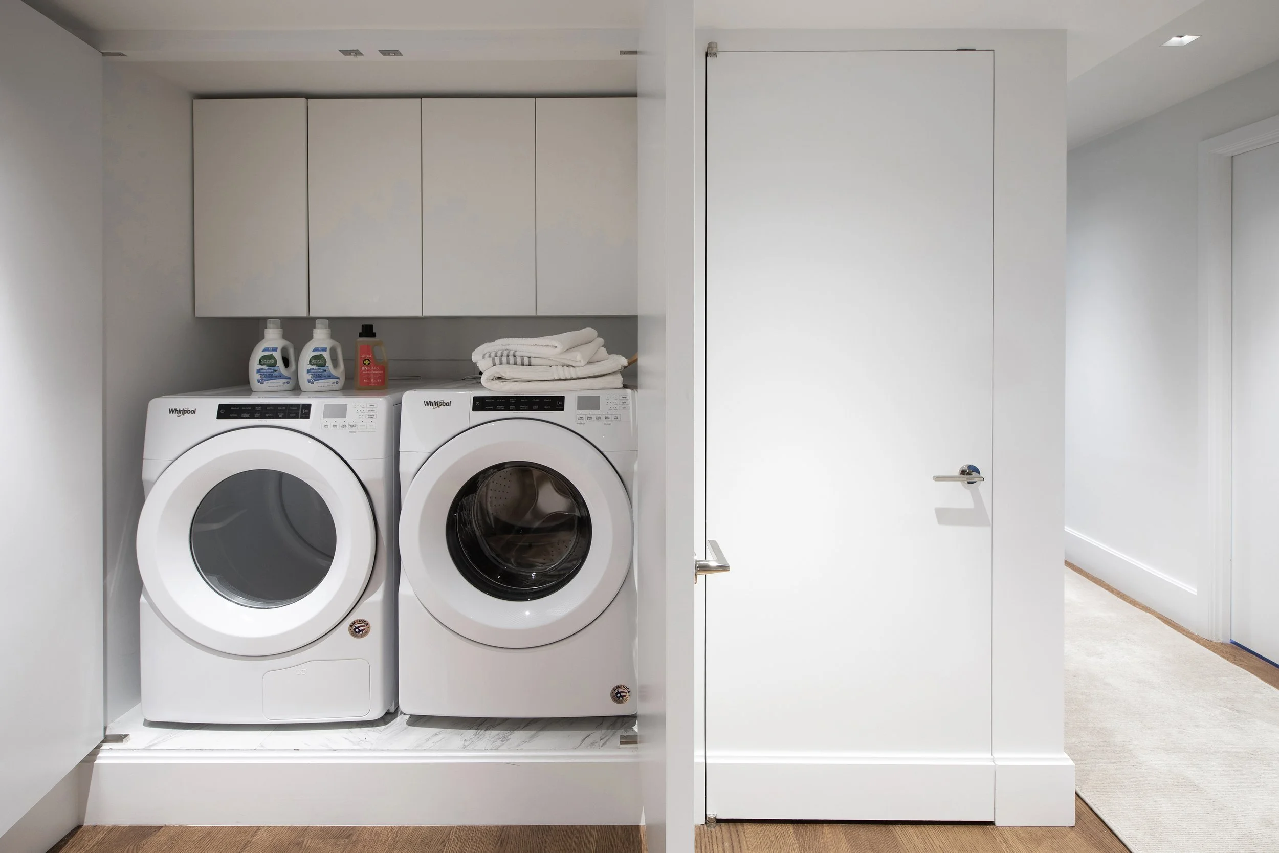 pivot doors open revealing in unit washer and dryer in a renovated and remodeled manhattan apartment