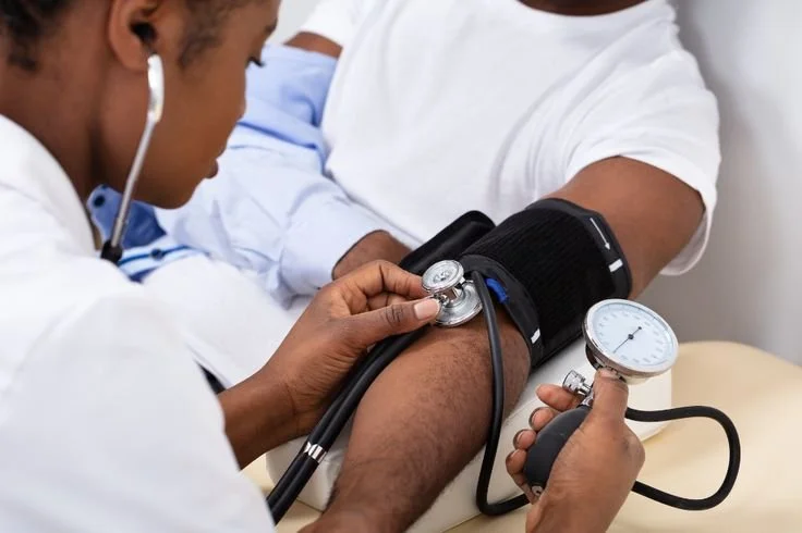 Healthcare professional taking a patient's blood pressure with a sphygmomanometer.