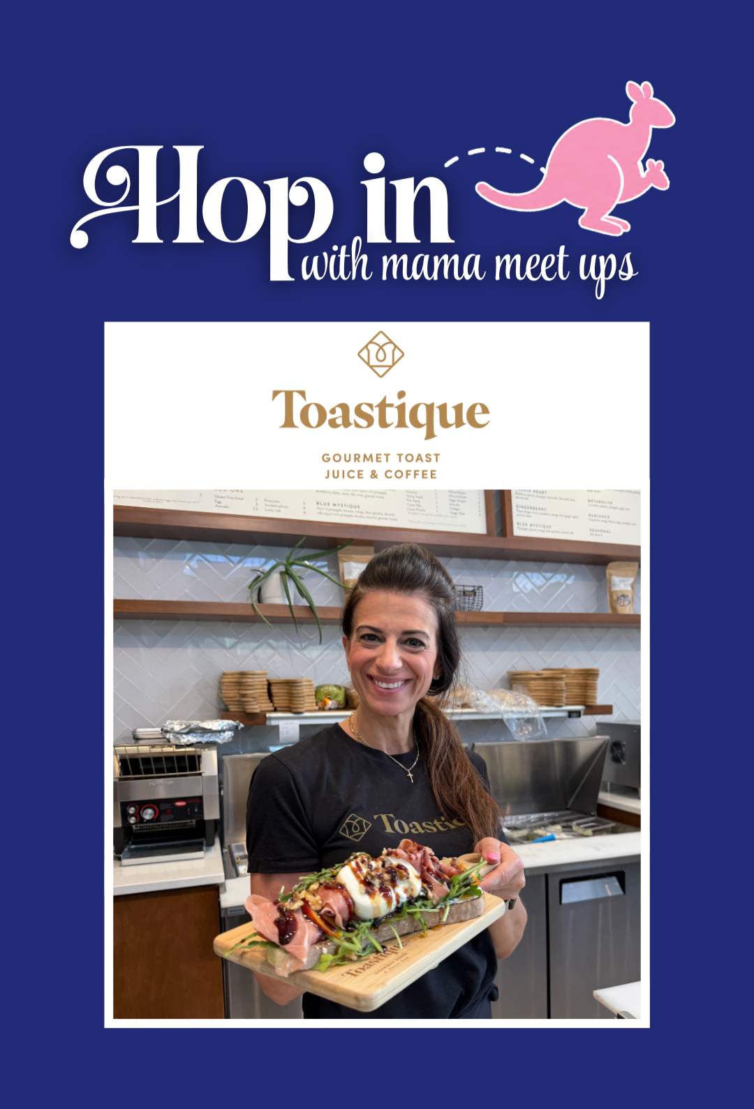 A woman with long brown hair smiling and holding a wooden platter with gourmet toast topped with meats, cheese, greens, and drizzled sauces, inside a cafe with a menu and kitchen background.