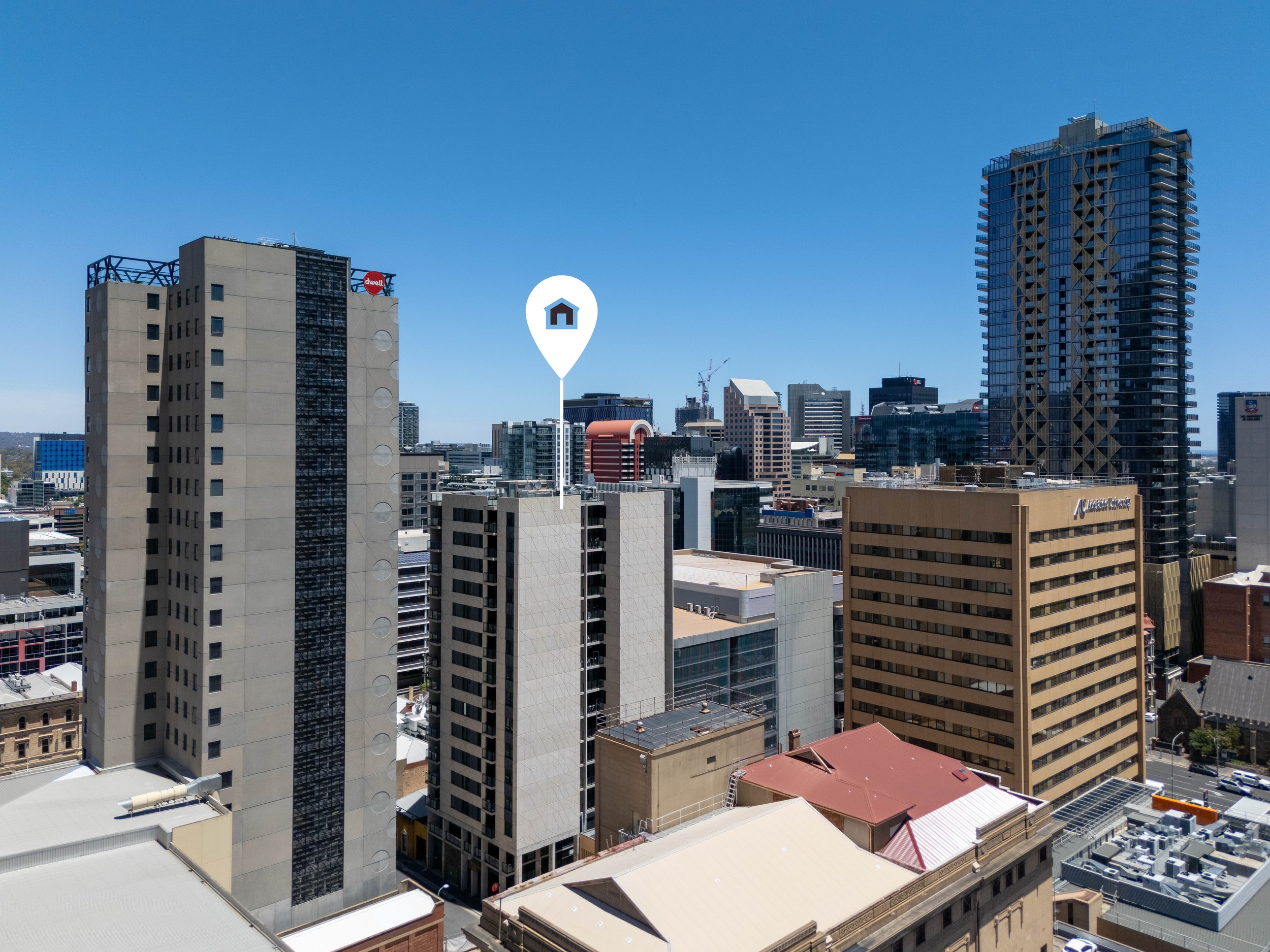 View of a city skyline with tall office buildings under a clear blue sky.