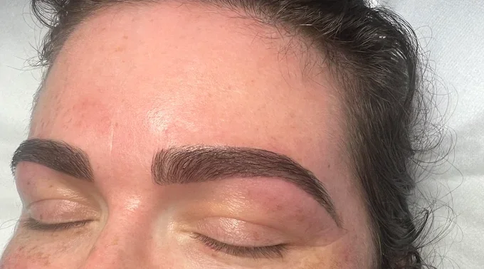 Close-up of a person's face with freshly done eyebrow tinting, closed eyes, and natural skin.