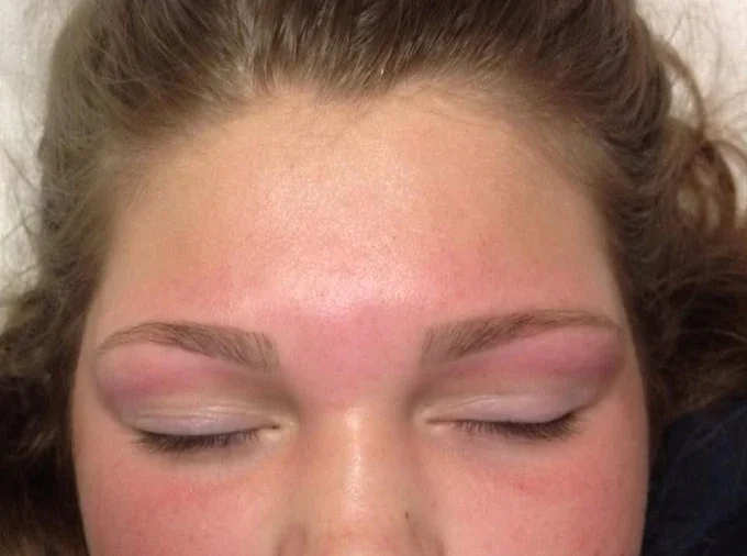 Close-up of a person's face with closed eyes, light makeup, and lightly tanned skin.