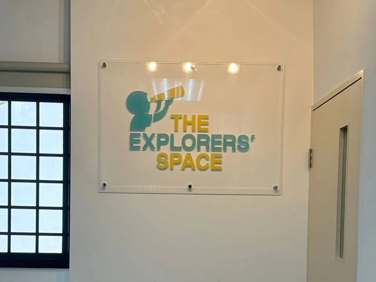 Sign on the wall that reads 'The Explorers' Space' with a graphic of a child looking through a telescope.