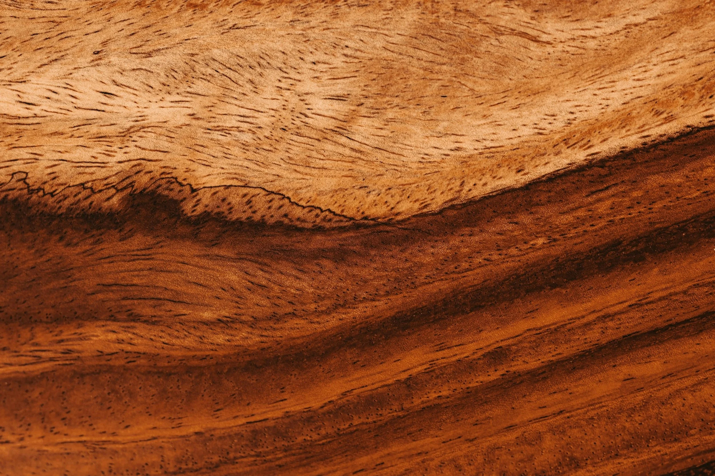 Close-up of polished wood surface with natural grain patterns and varying shades of brown