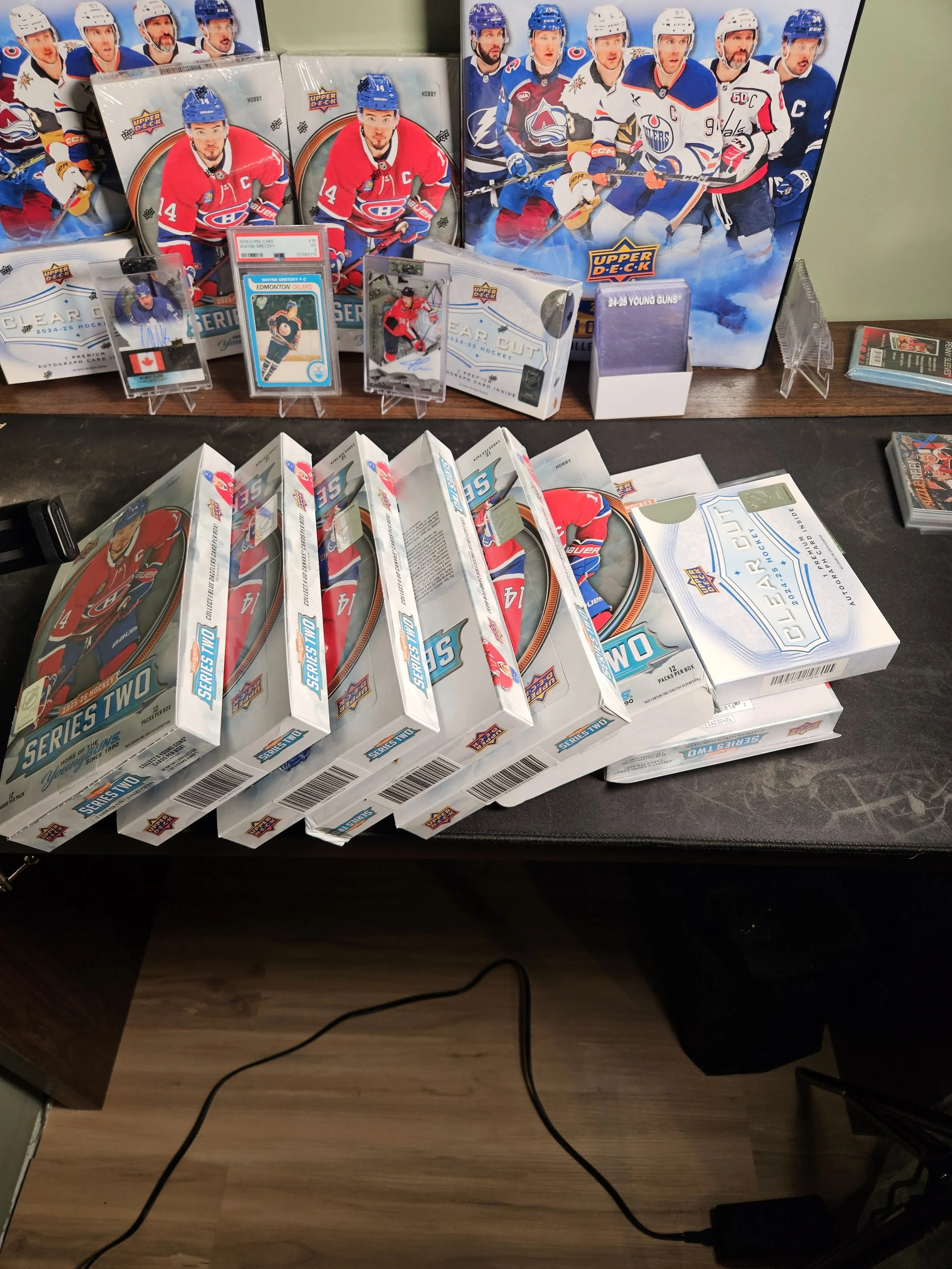 Table with hockey trading card packs, hockey cards, and hockey-themed merchandise, including boxes with hockey team logos and promotional items, all related to ice hockey.