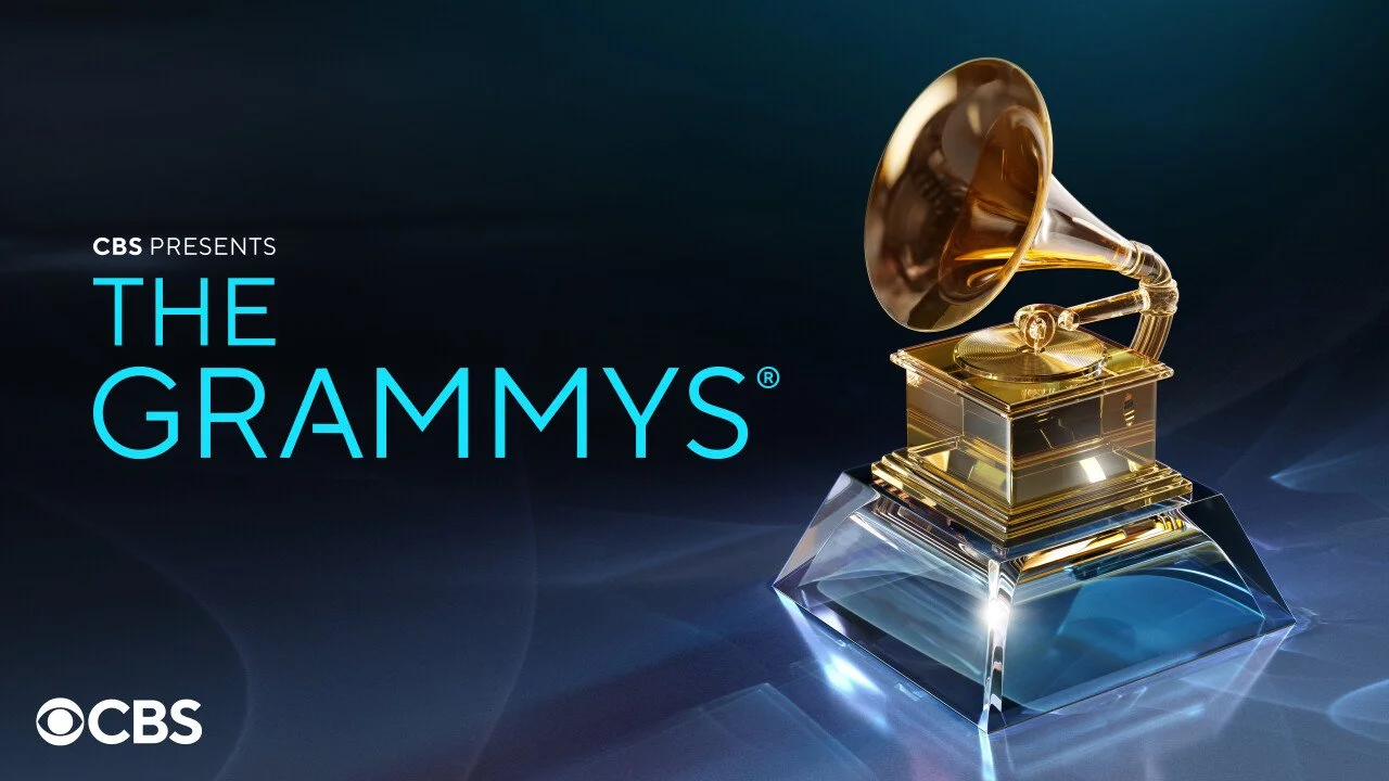 The image shows a golden gramophone trophy sitting on a glass base with a dark blue background, representing the Grammy Awards. Beside it is text that reads "CBS Presents The Grammys" in blue and white.