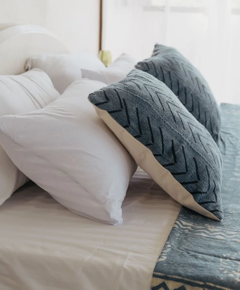 a close up shot of plump blue pillows on a made up bed