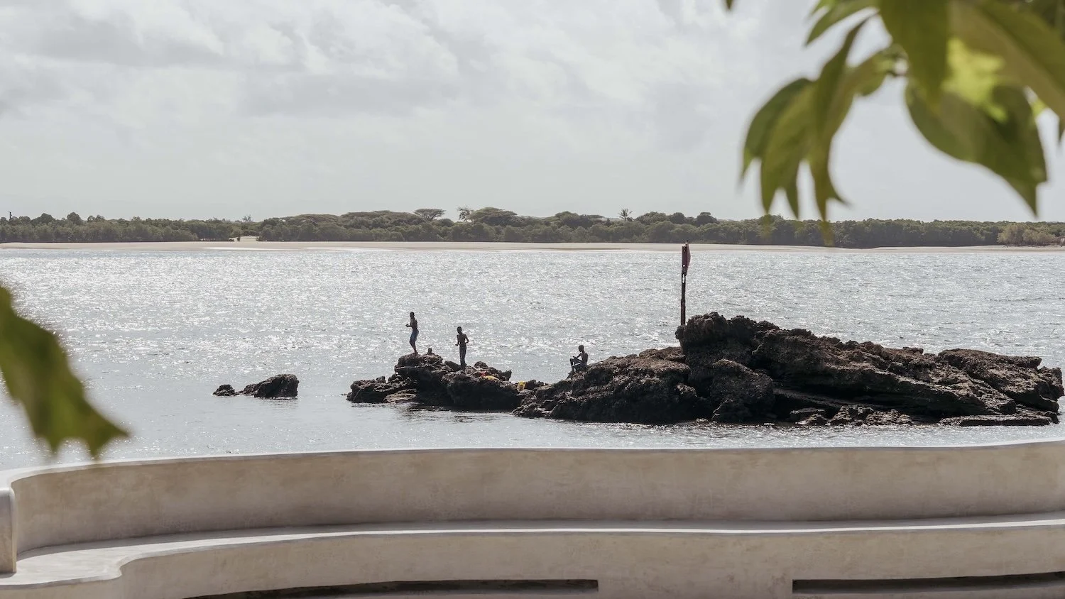 Boys fishing off coral rocks in Shela Village
