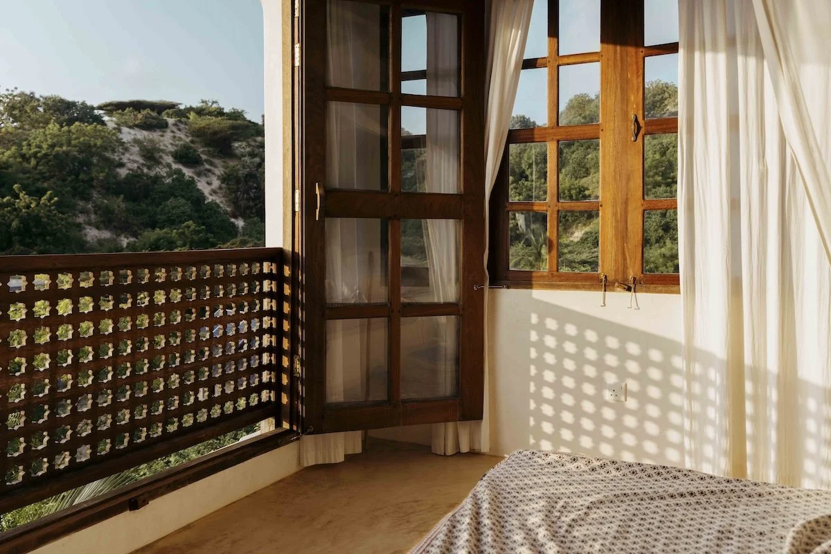 Warm sunlight shining through a full length door into a bedroom