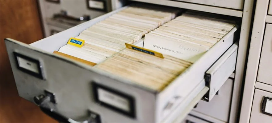 Open filing cabinet drawer filled with neatly organized manila folders.