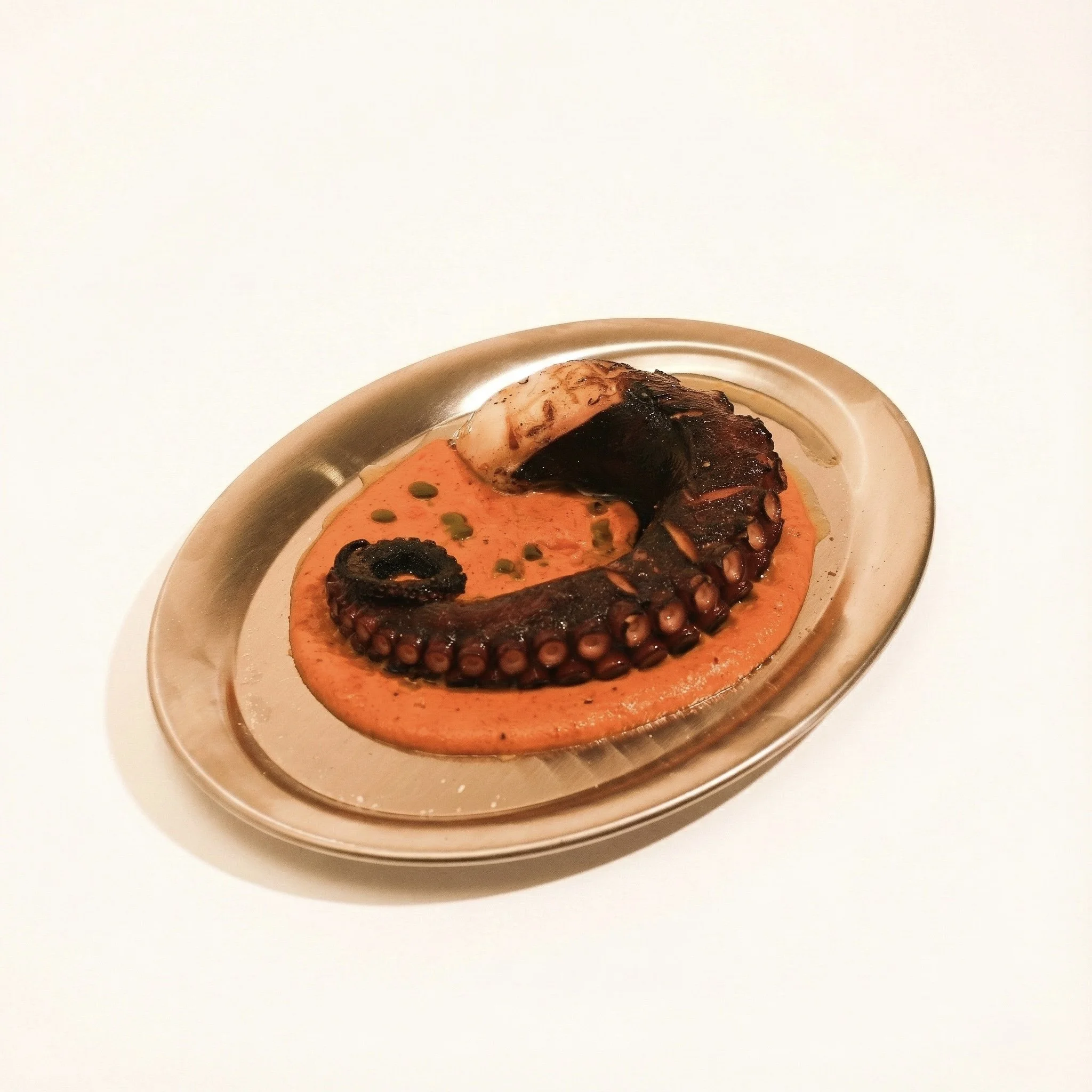 GRILLED OCTOPUS · Tender grilled octopus with a warm romesco sauce and kaffir lime oil · 890