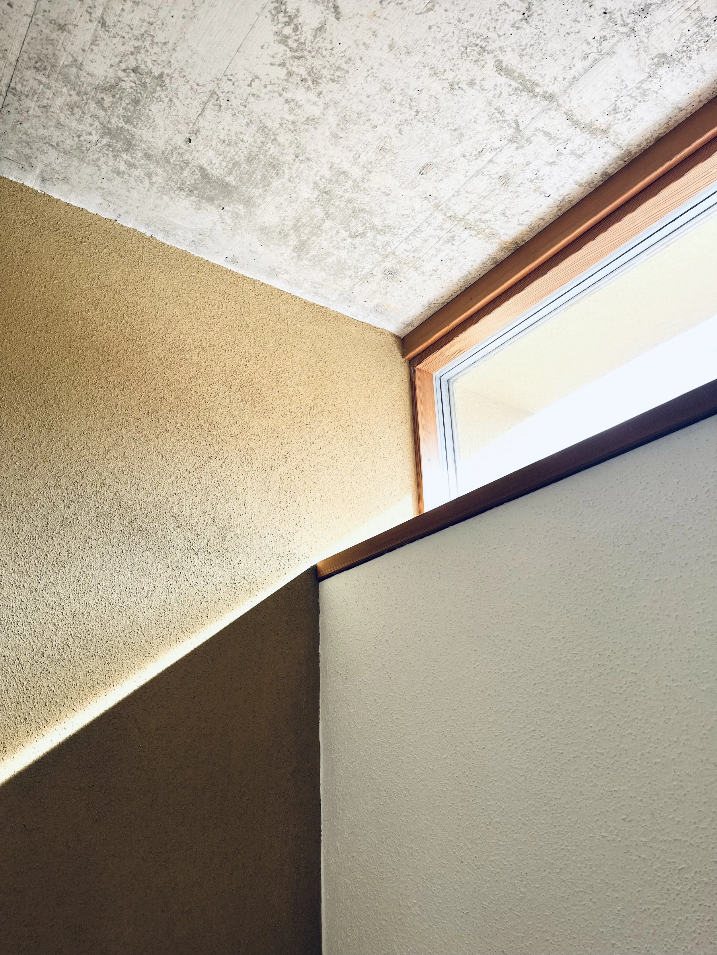 Innenraum mit verschiedenen Wandfarben und einem Fenster an der Zimmerdecke.