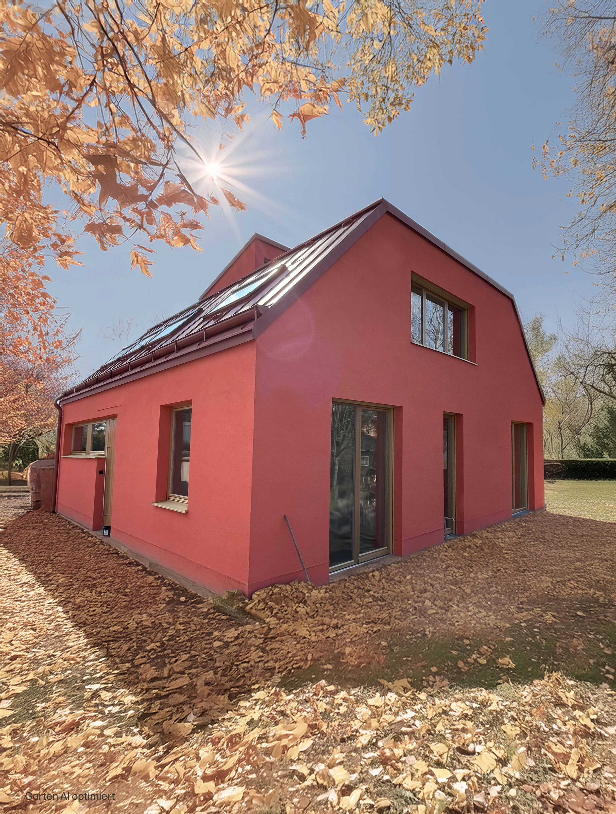 Ein lachsrotes, modernes Haus mit großen Fenstern und einem geneigten roten Blechdach, umgeben von Bäumen mit Herbstblättern, auf einem Grundstück mit Laub.