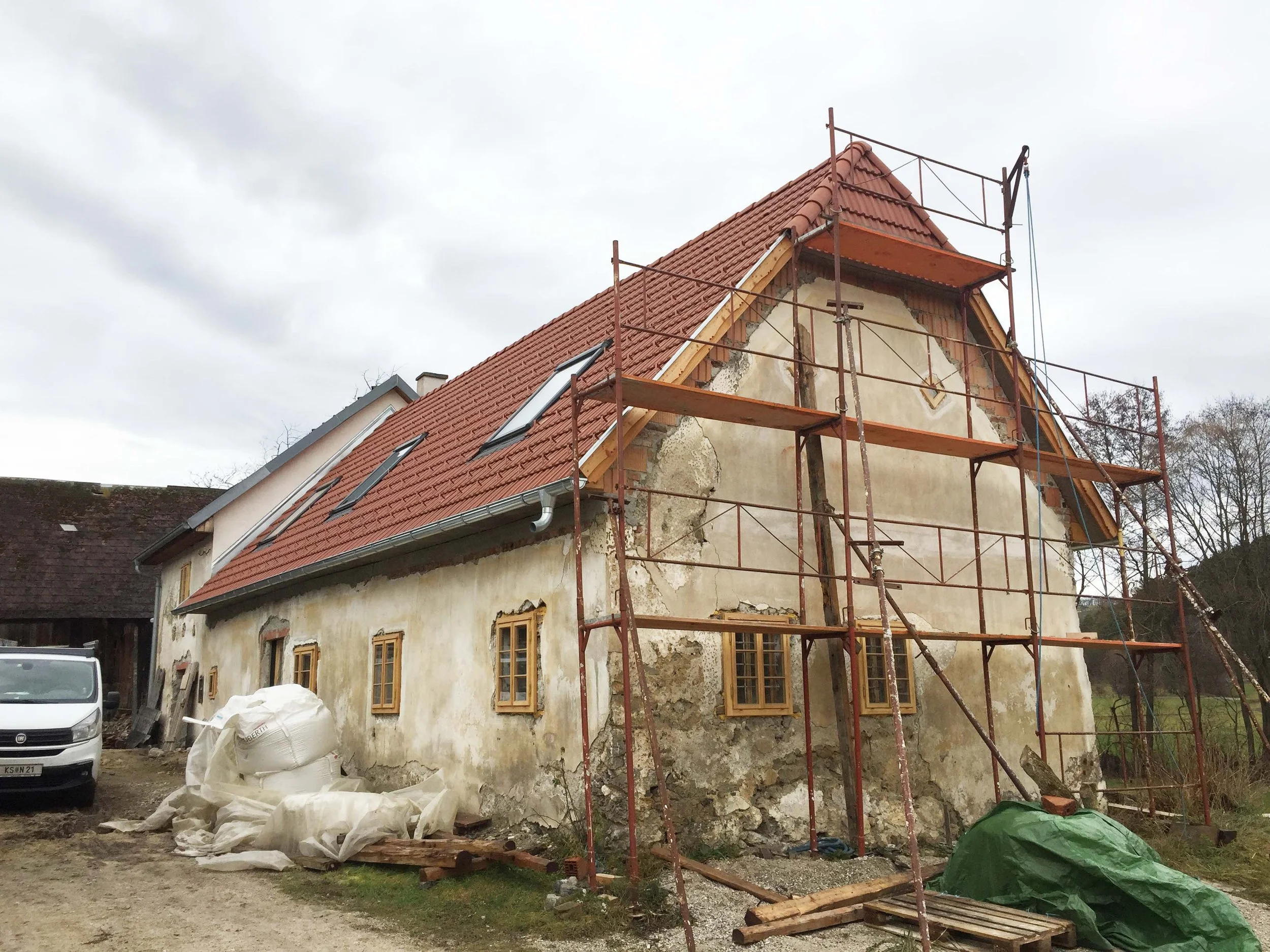 Altstadt Haus wird renoviert, es ist Baugerüst um das Gebäude aufgebaut, das Haus hat eine alte, beschädigte Fassade und neue Dachziegel, Fenster sind neu eingebaut.