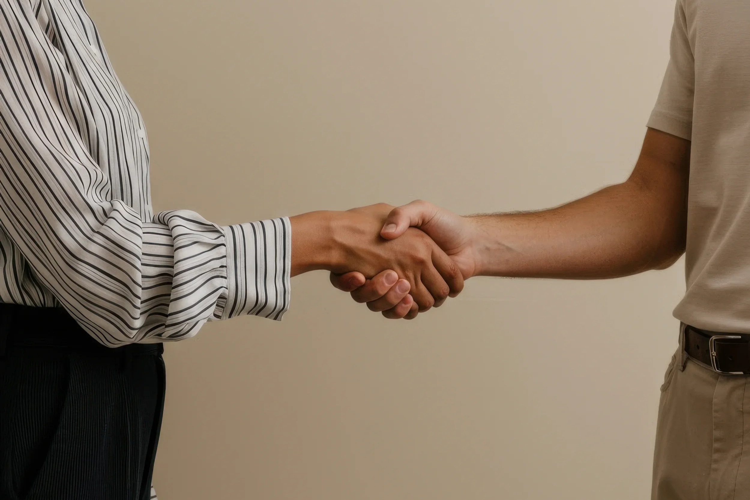 Zwei Personen begrüßen sich mit einem Handschlag.