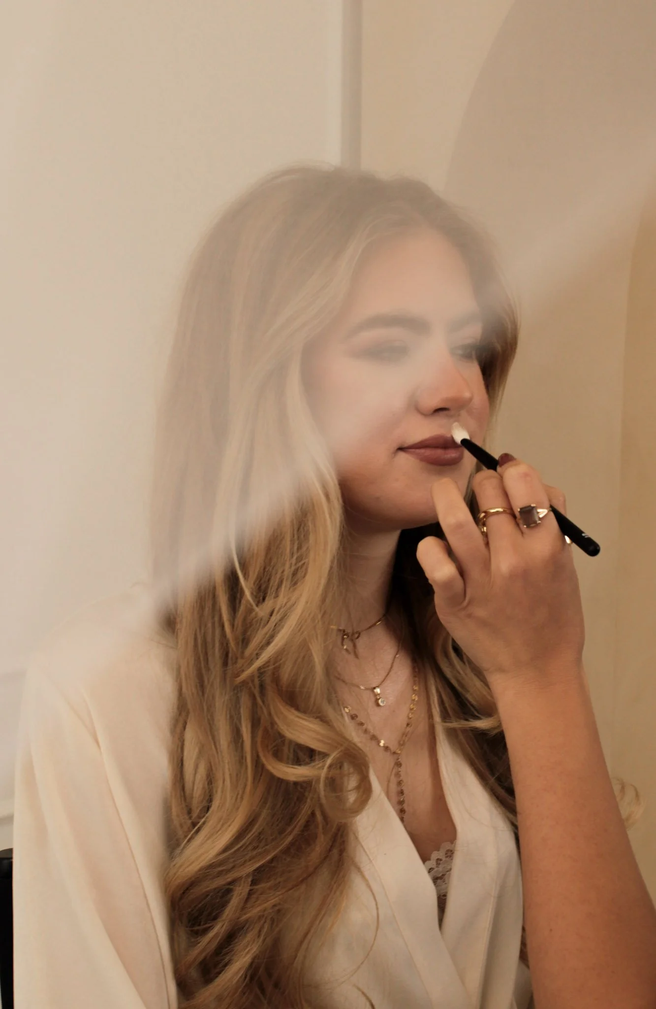 Bridal makeup artist applying lipstick during wedding morning preparation in the Netherlands and Italy