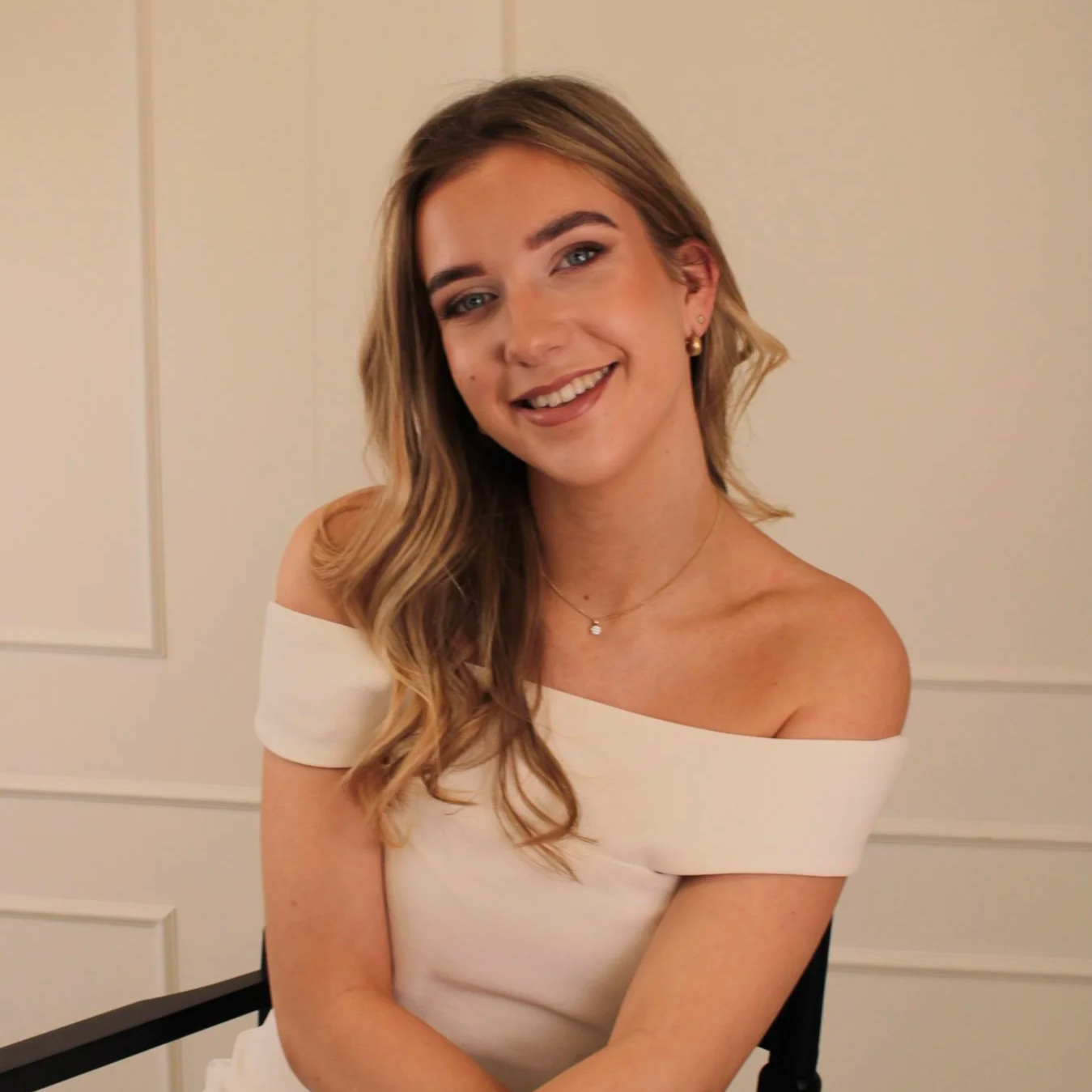 Natural bridal makeup with soft glow and neutral tones, styled in an elegant off-shoulder look by Studio Imeliana.