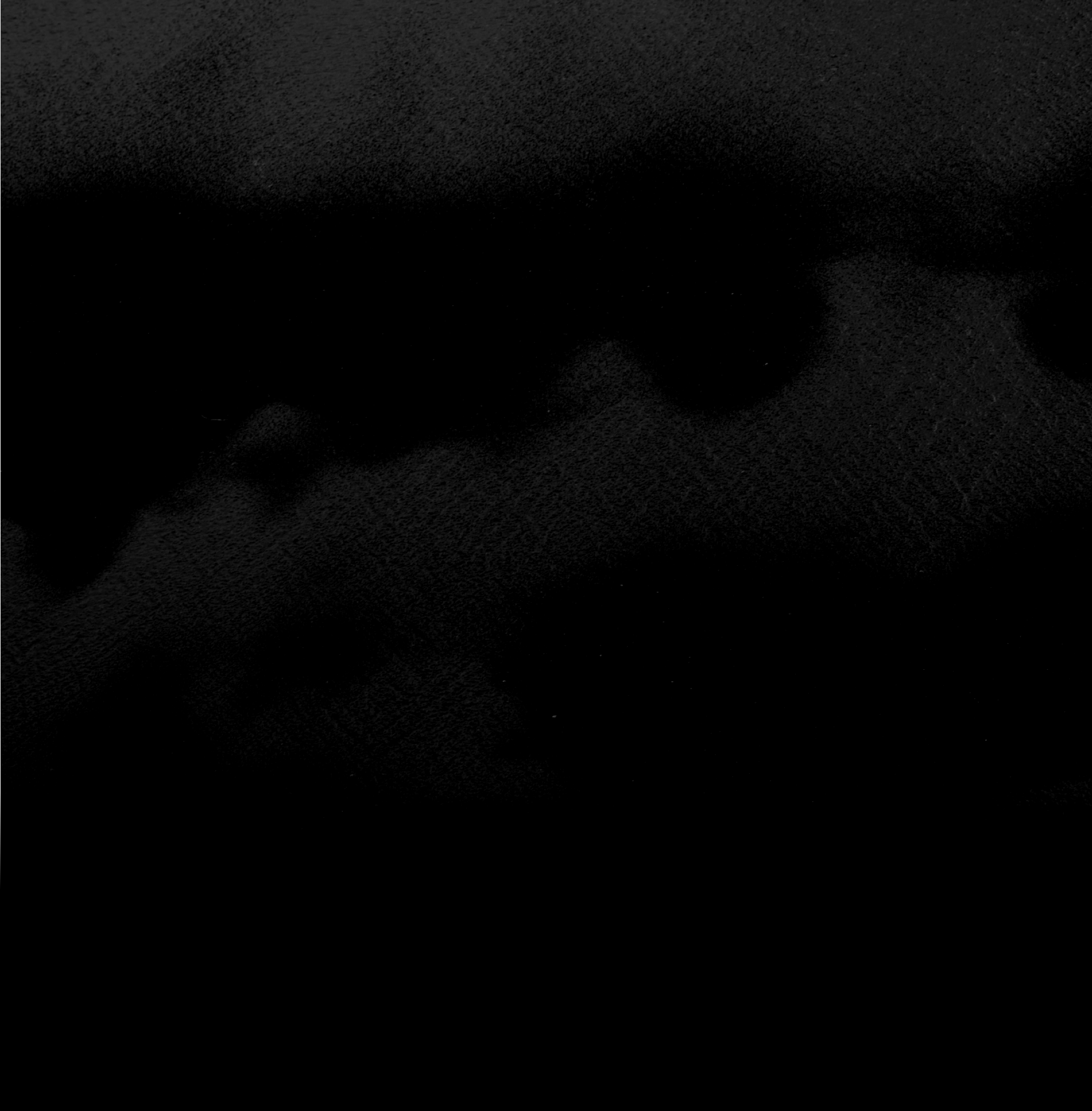 Close-up view of a black, textured, quilted fabric surface.