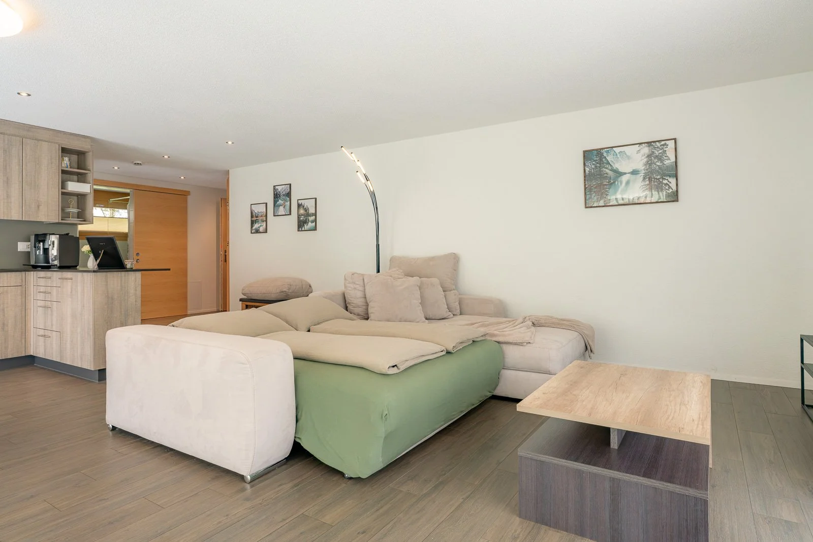 Modernes Wohnzimmer mit großen Sofas, Wandbild und einem kleinen Kaffee- oder Beistelltisch.