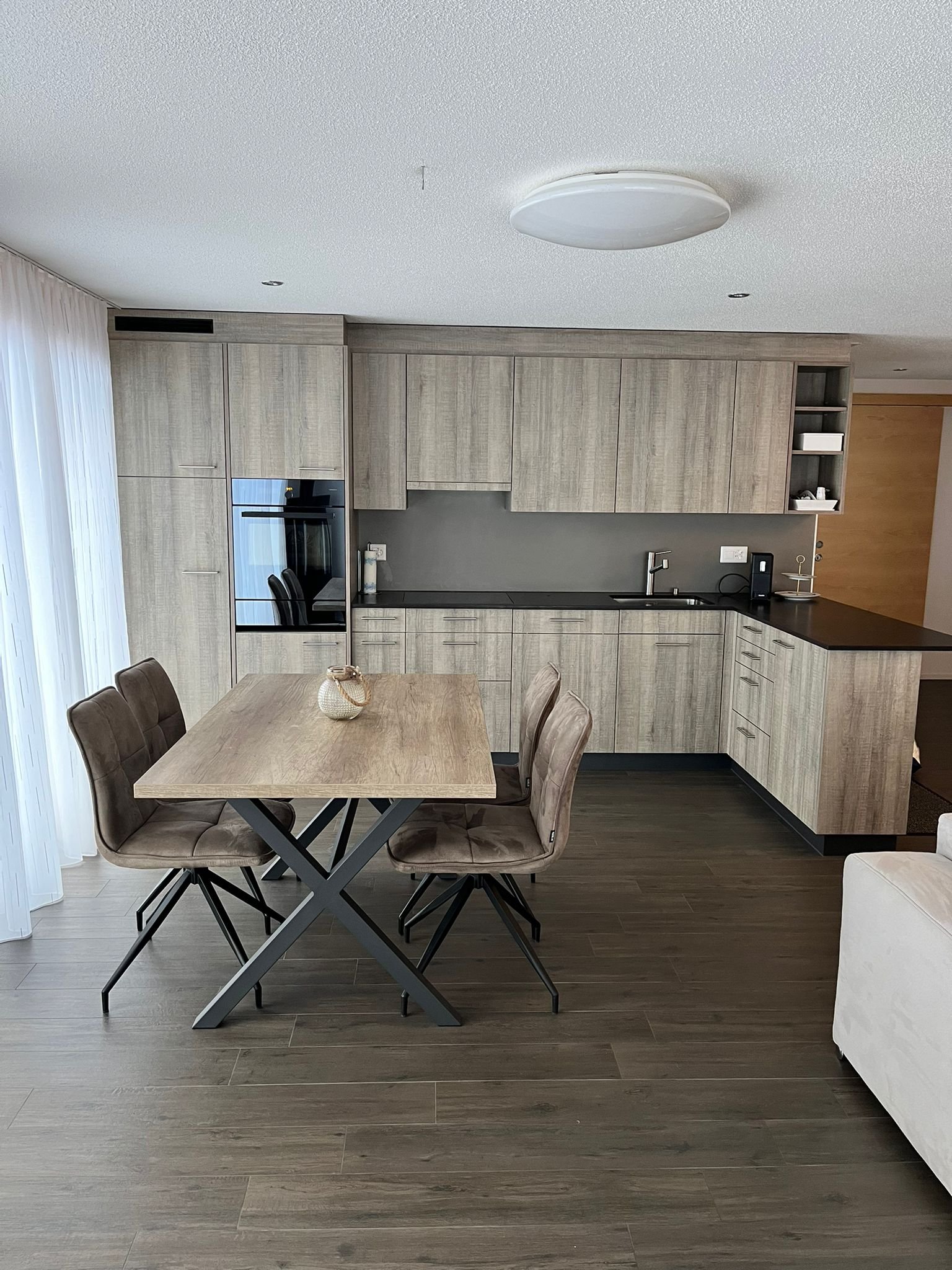 Moderner Küchenbereich mit Esstisch und Stühlen in einem hellen, eleganten Raum.