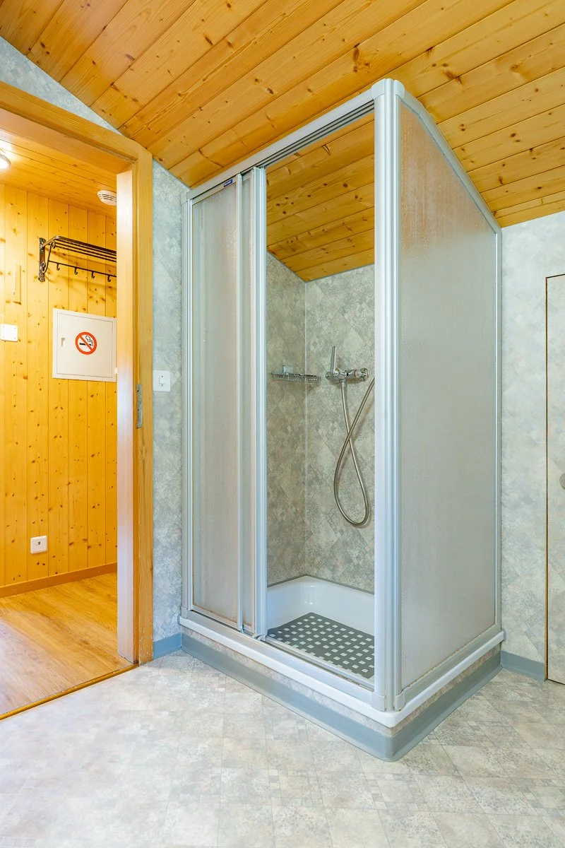 Kleines Duschkabinen in einem Raum mit Holzdecke und Holzpaneel-Wand