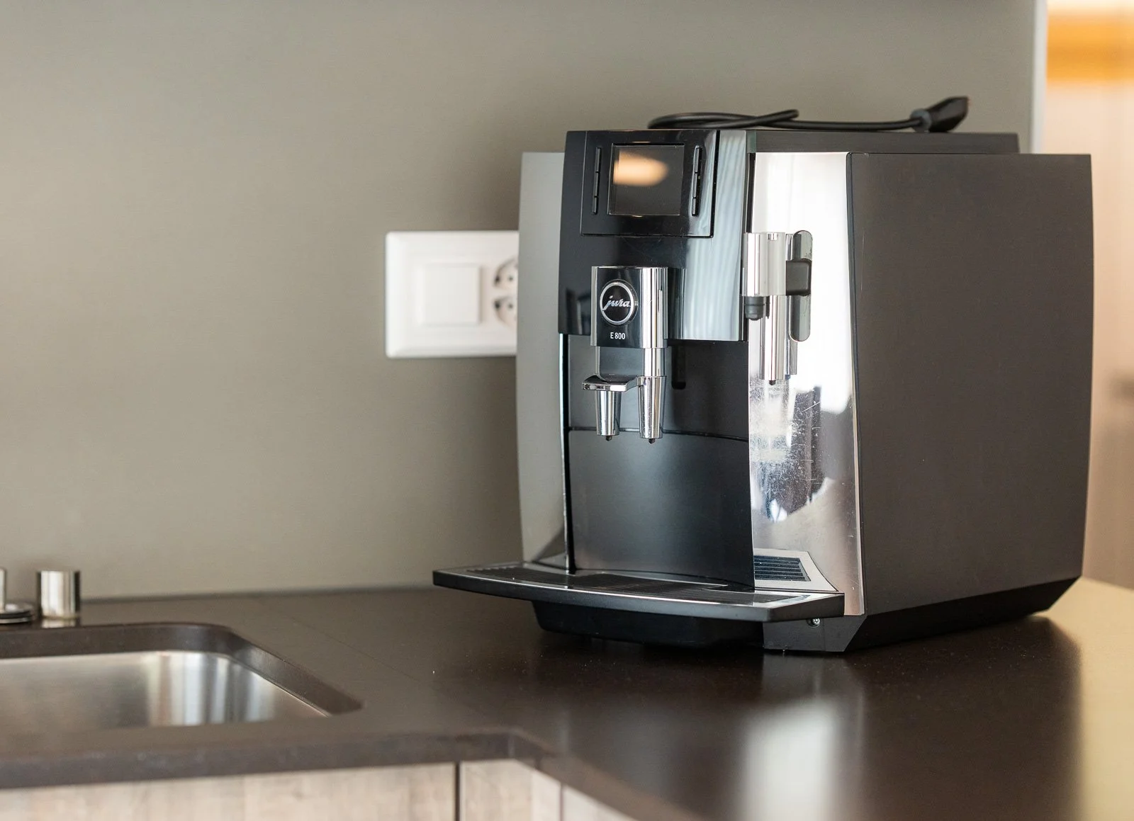 Kaffeemaschine auf einer Küchentheke neben einem Spülbecken.