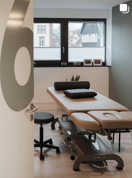Behandlungsraum mit Liege, Kissen und Fenster