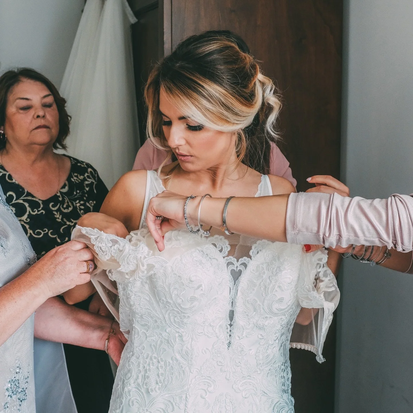 La Cura: Mani esperte e affettuose che si intrecciano intorno alla sposa, ogni gesto &egrave; un rito di protezione e amore.