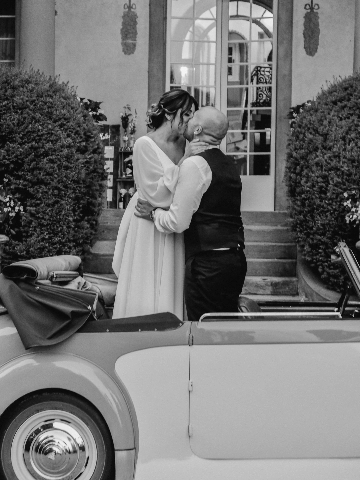 Dal mio mirino, non vedo solo due persone; vedo una storia di movimento e stasi. C&rsquo;&egrave; il movimento implicito dell&rsquo;auto pronta a partire e la stasi assoluta del bacio. La luce naturale accarezza i profili, creando un gioco di luci e 