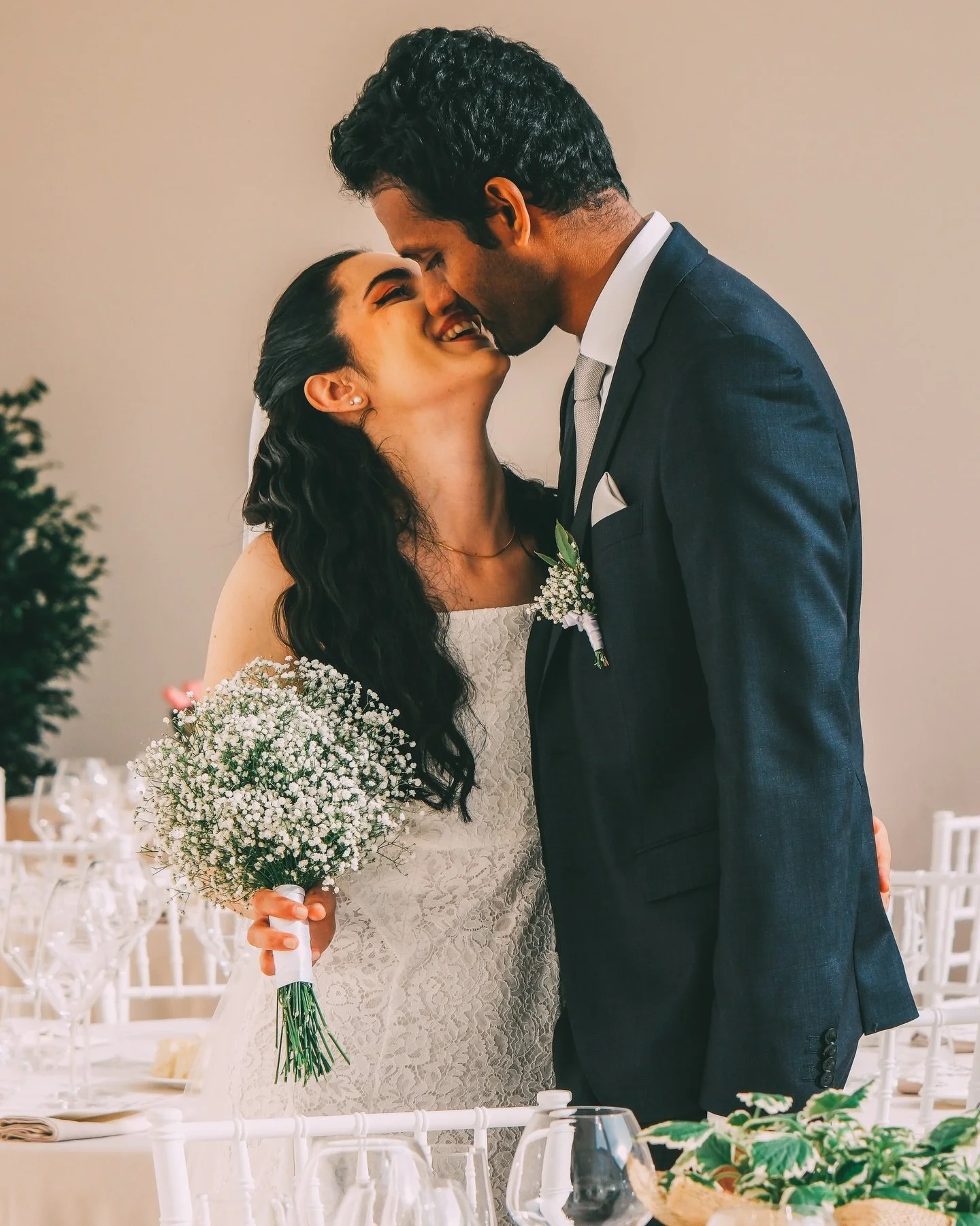 In questo scatto non vedo solo due persone, ma l&rsquo;abbraccio profondo tra due mondi che si scelgono, dove il bianco purissimo del pizzo italiano e la delicatezza del bouquet sembrano accogliere e celebrare la fiera eleganza di una storia che vien