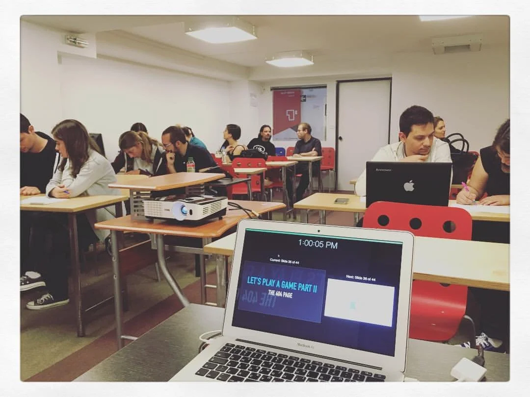 Classroom with students and a laptop screen showing a game in progress.