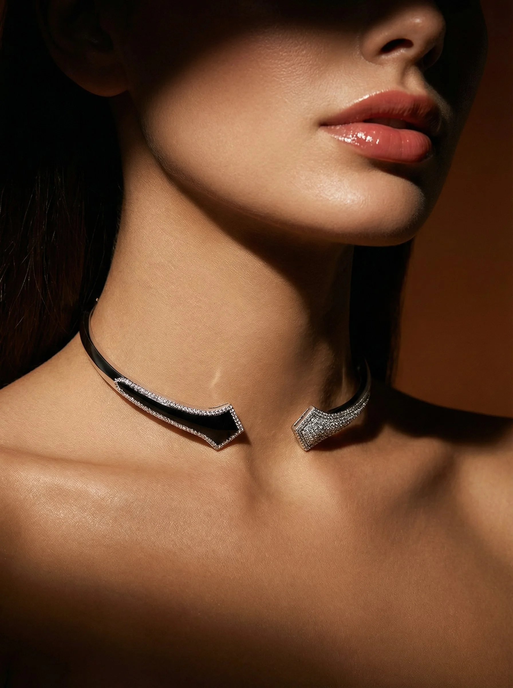 Close-up of a woman's neck and lips, featuring a black and silver choker with sparkling details.