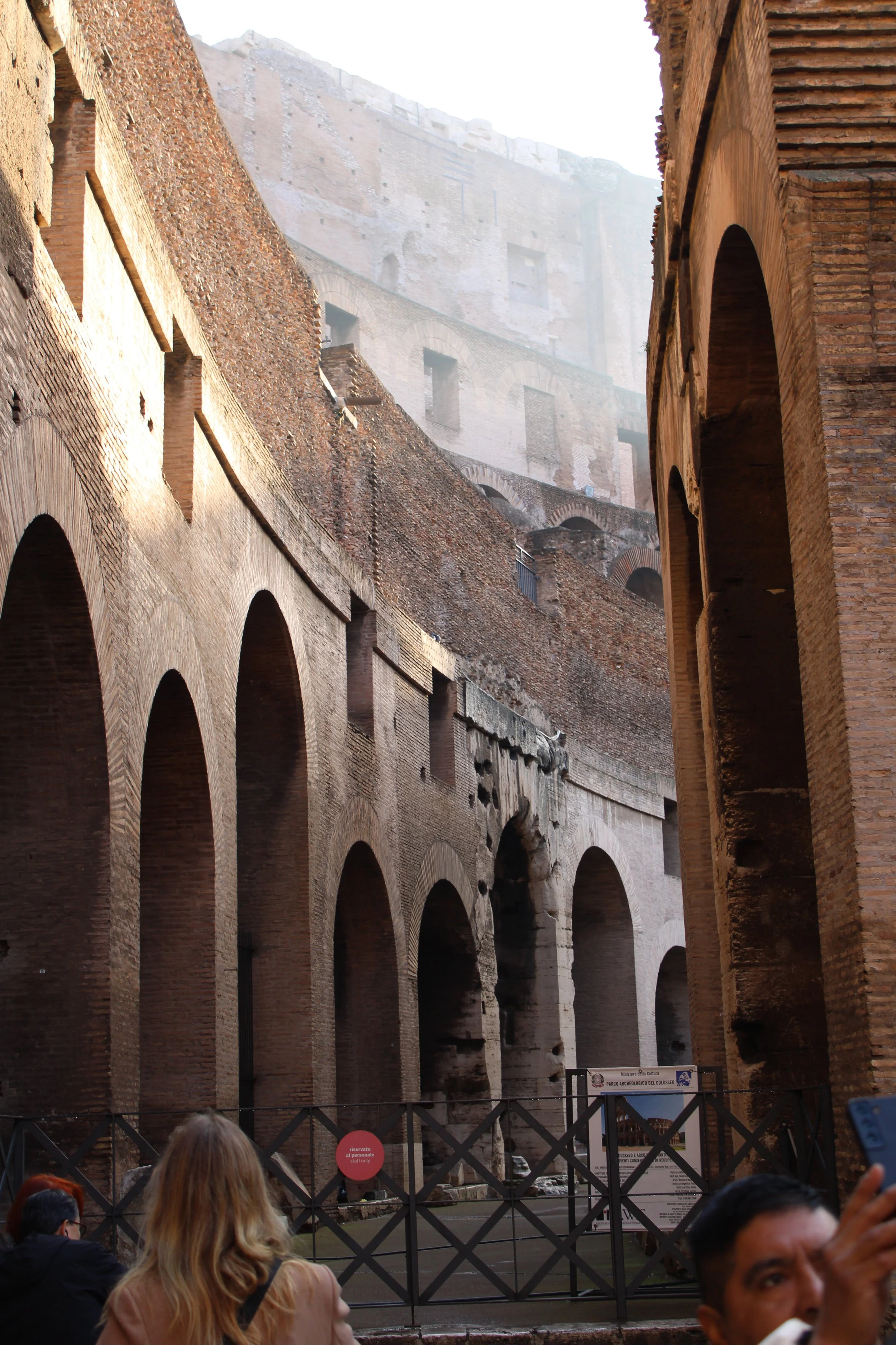 View of ancient Roman ruins with brick arches and walls, with a group of people in the foreground.