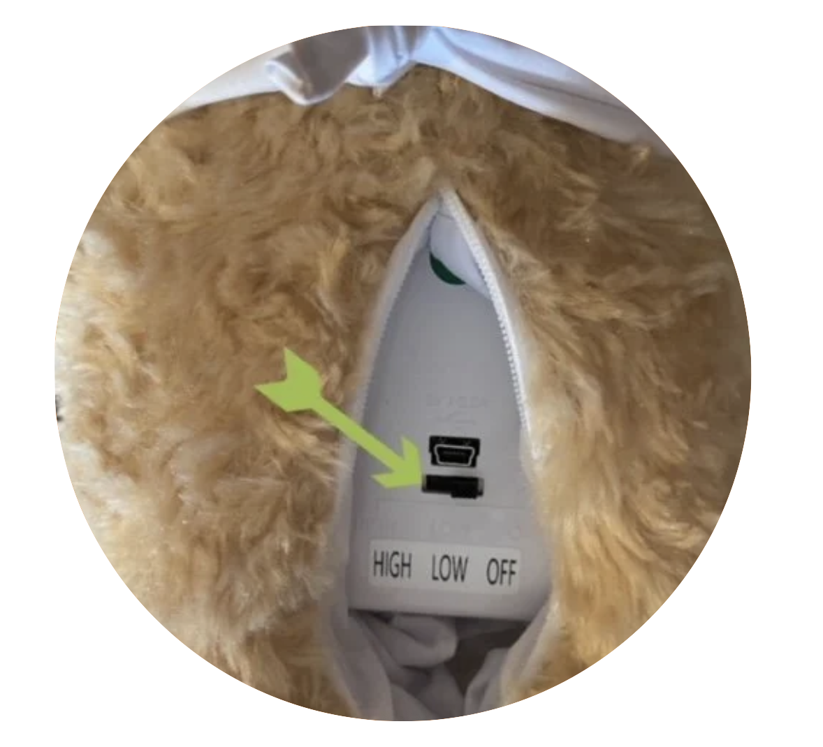 Close-up of a furry garment with a control panel inside, featuring a switch labeled 'HIGH LOW OFF' and digital display, with an arrow pointing to the panel.