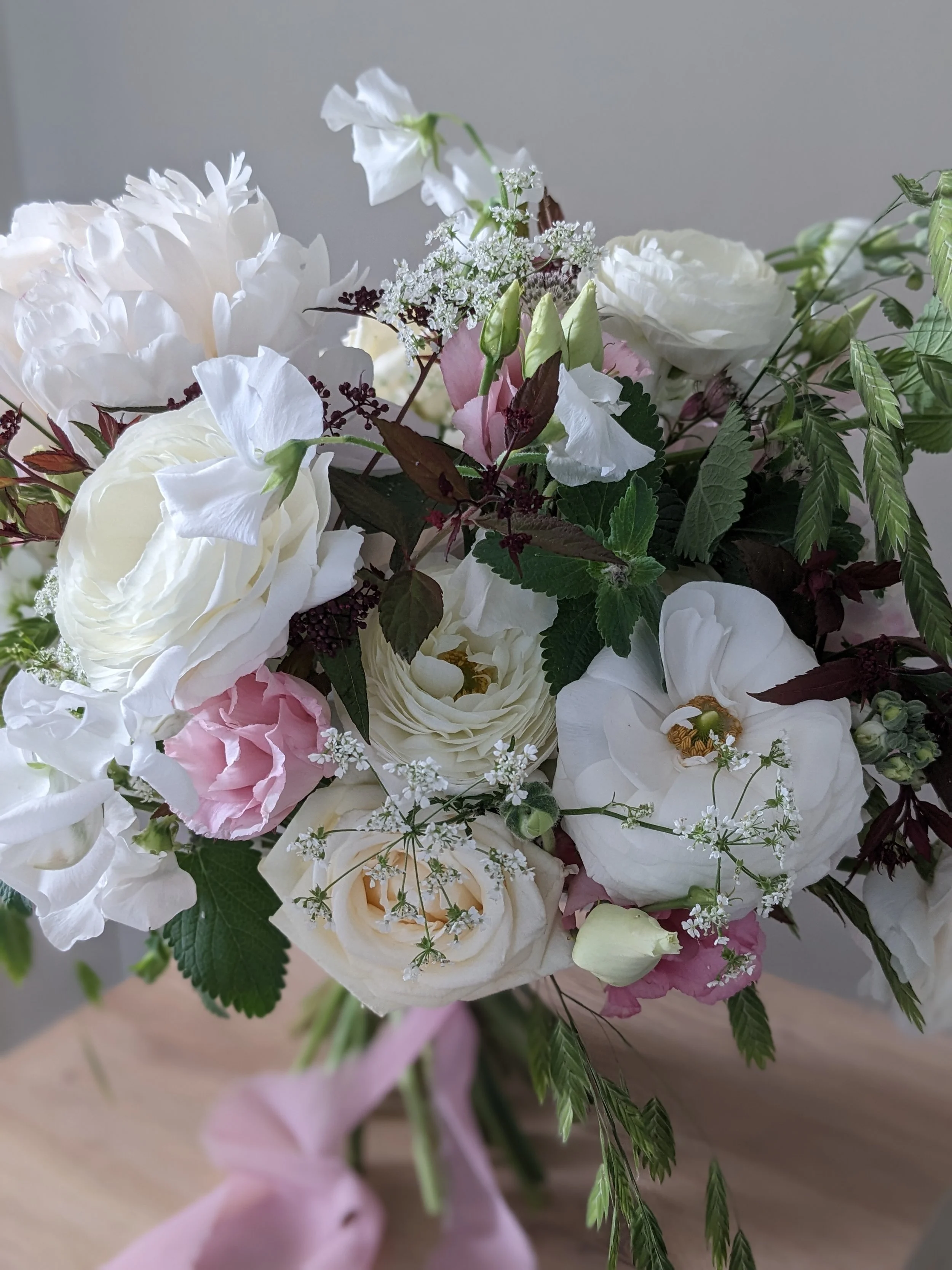 White, pale pink and burgundy spring flowers bridal bouquet