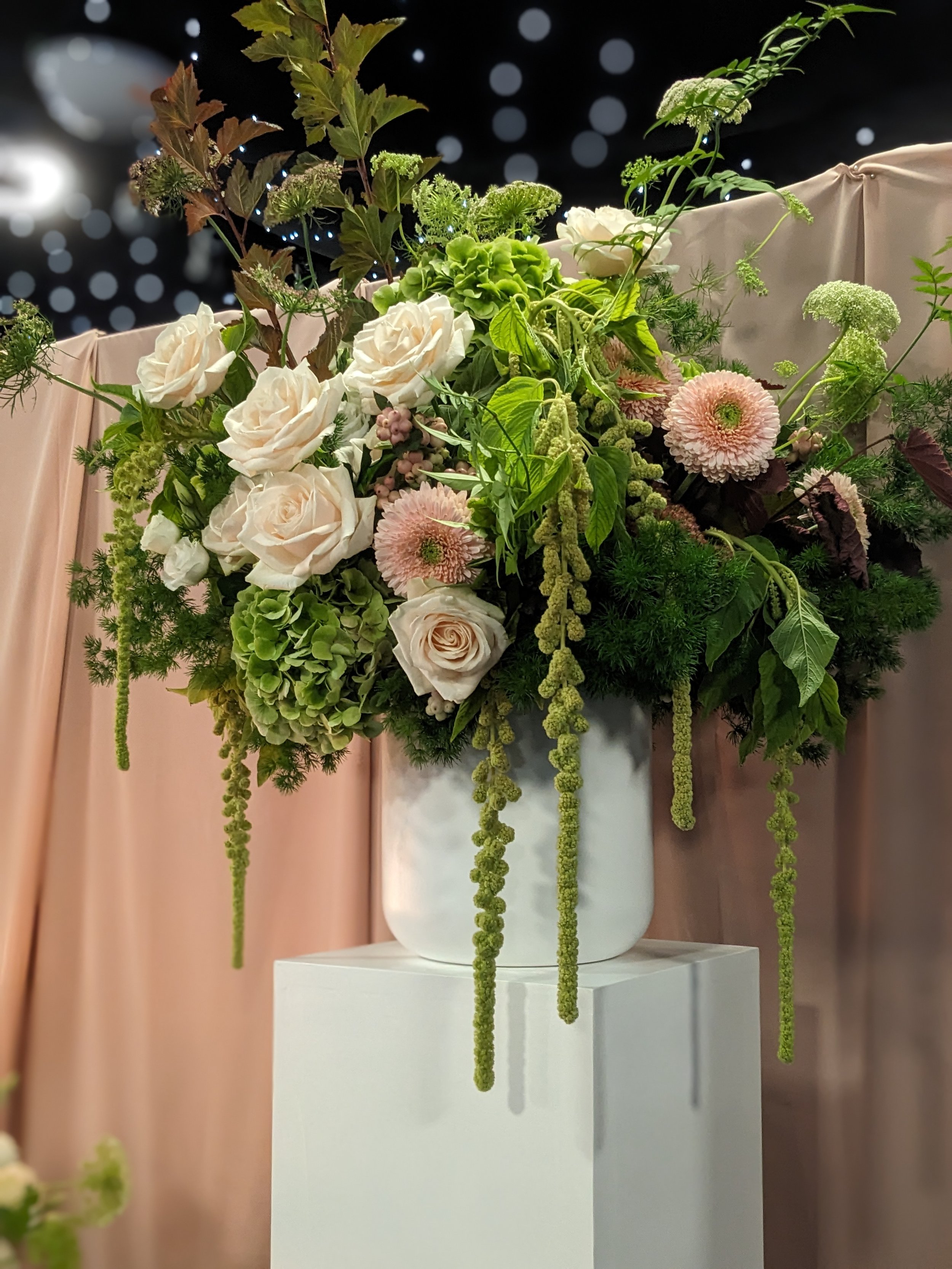 Wedding ceremony pedestal arrangement peach roses and green hydrange