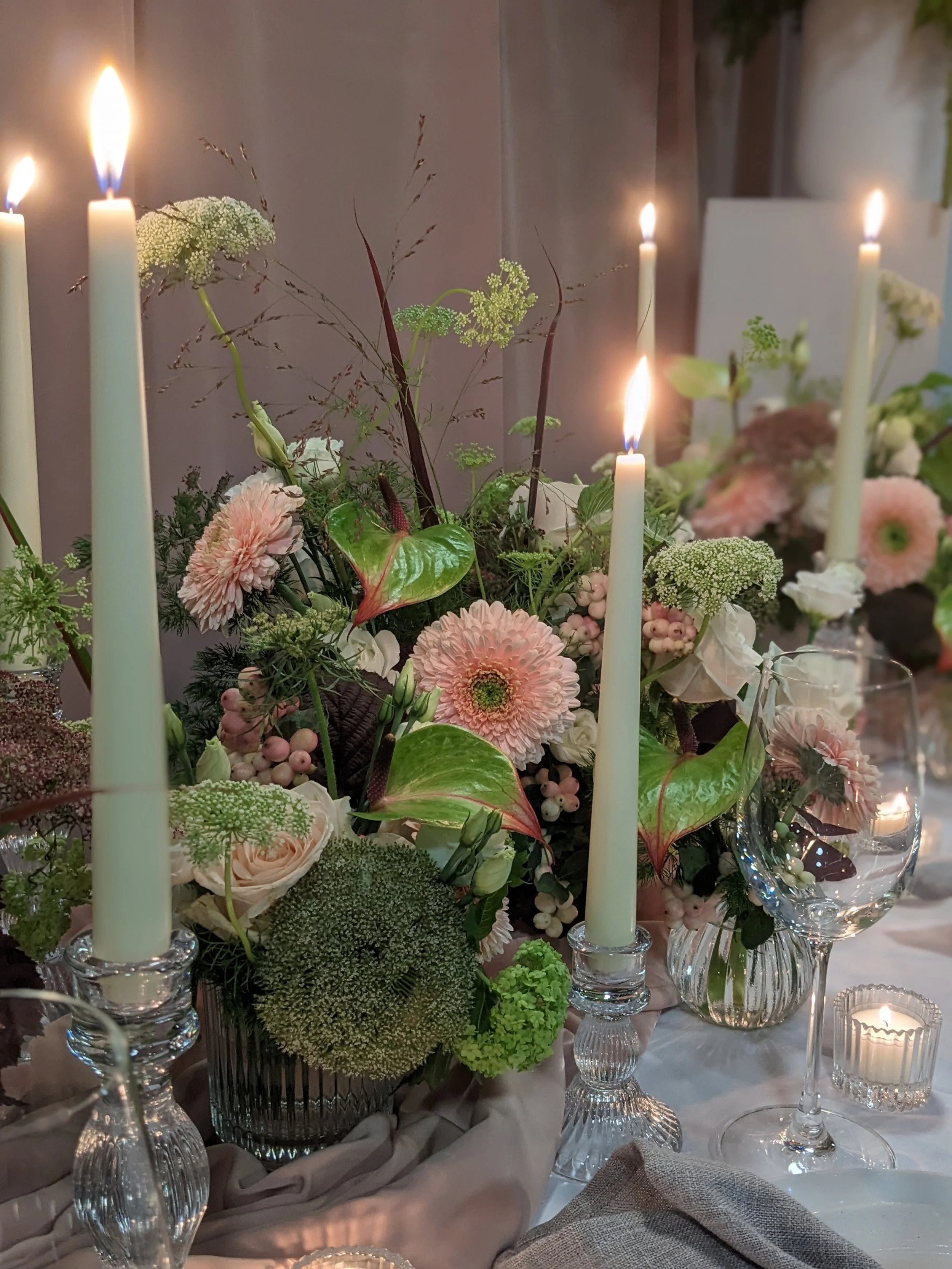 Peach and green flower vases with candles wedding top table