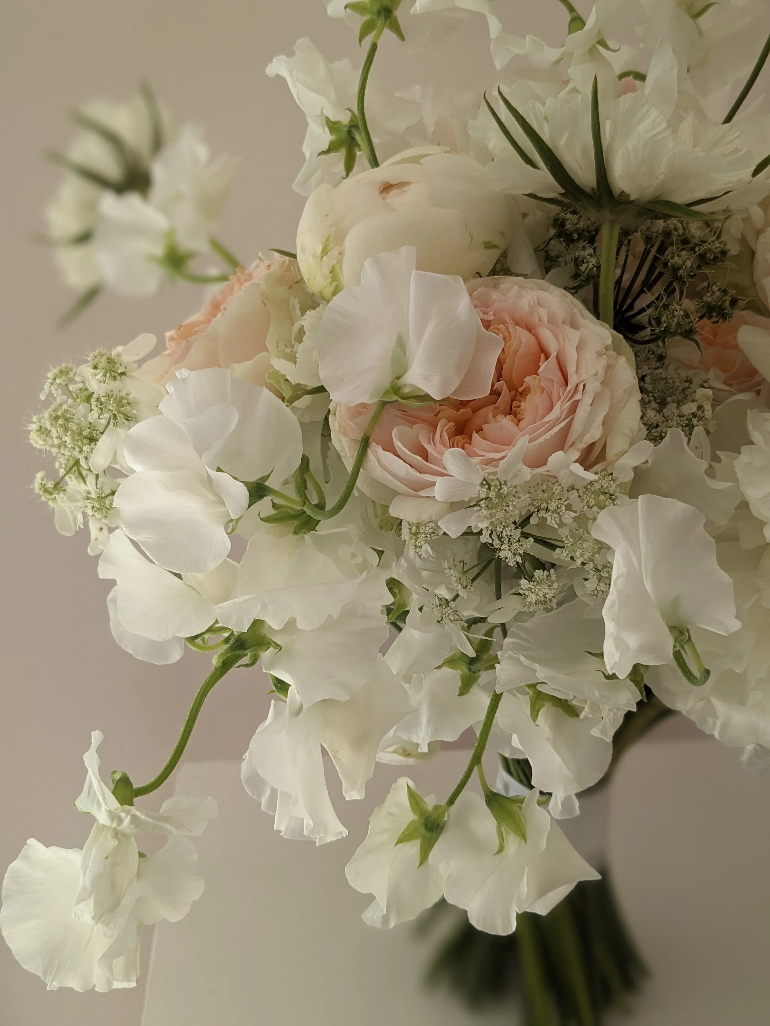 Bridal bouquet white sweet peas, peach garden roses and white peonies