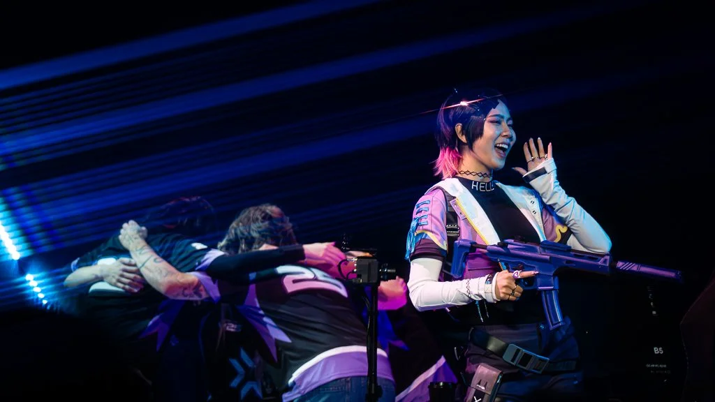 Team Tarik preparing for his show match while a Clove the Valorant agent cosplay hypes the crowd.