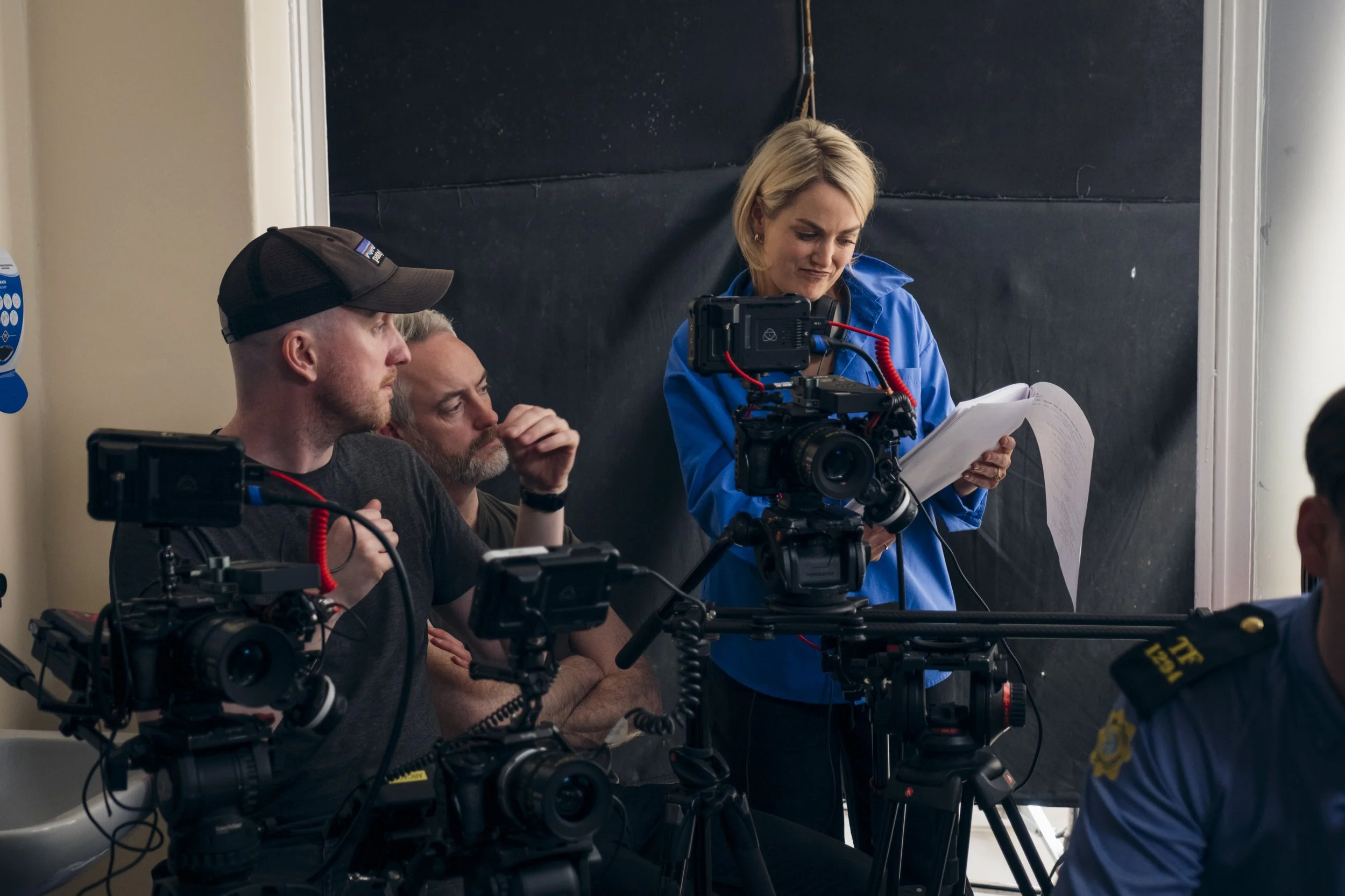 A film crew setting up camera equipment and reviewing script and shot list during a production interview or scene.