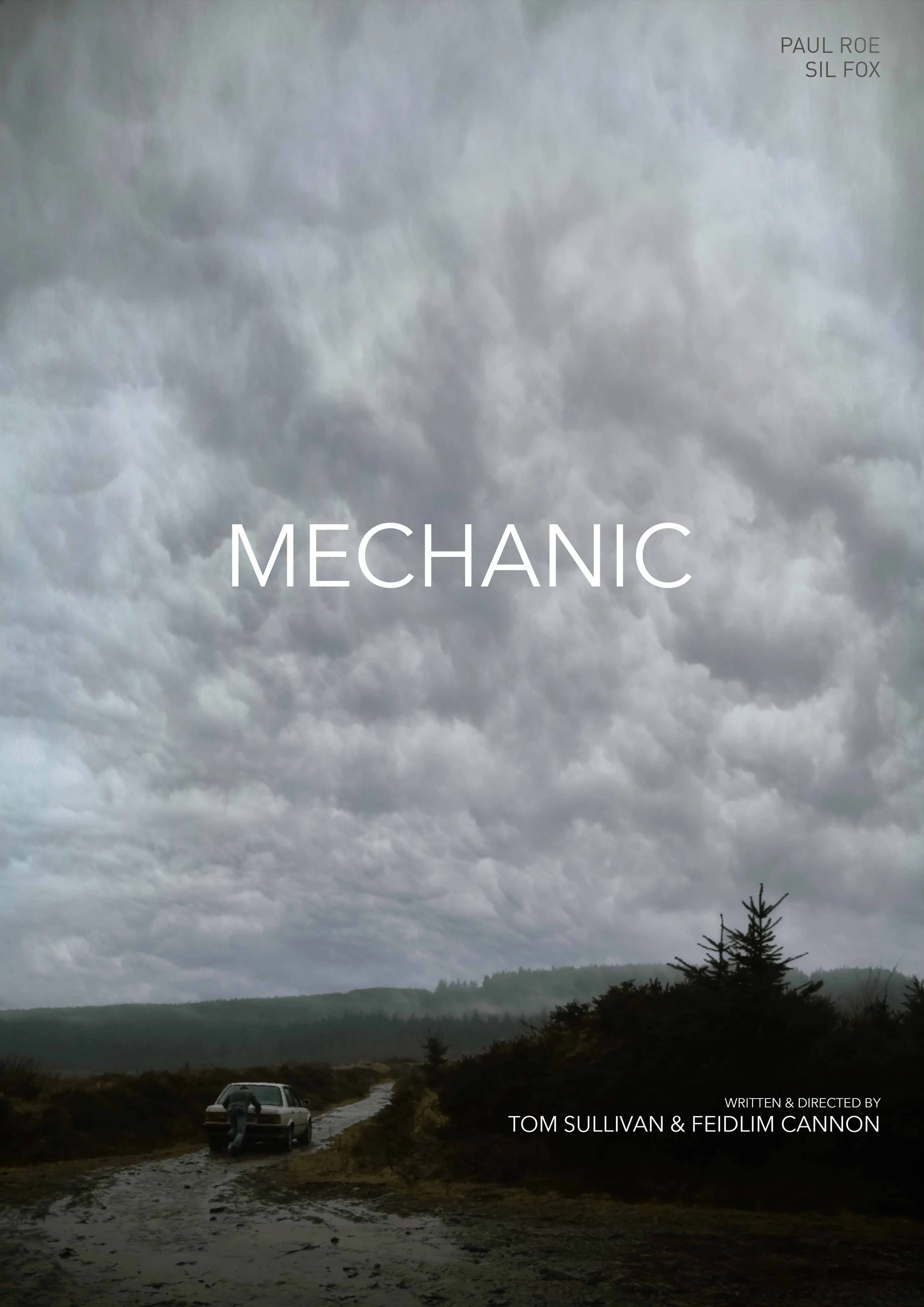 A cloudy landscape with a muddy dirt road, a parked vehicle, and an individual near the car, with trees and hills in the background. Title text reads 'Mechanic' and credit to writers and directors Tom Sullivan & Feidlim Cannon.