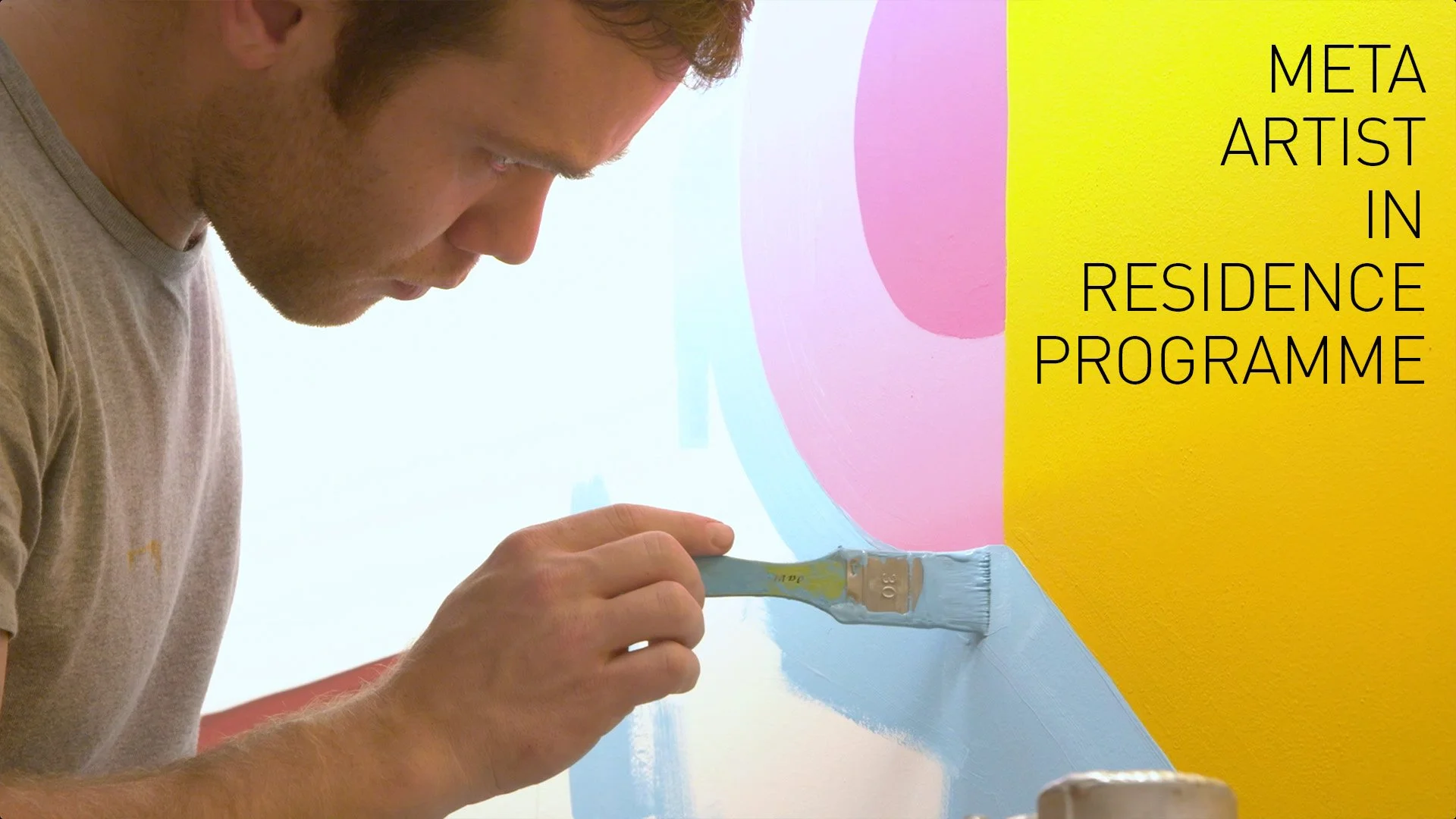 A man painting a colorful mural on a wall, with the text 'Meta Artist in Residence Programme' written on the right side of the image.