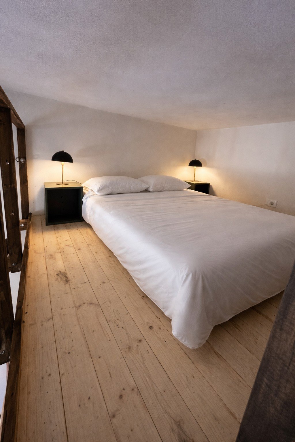 Comfortable bedroom with wooden floors and simple, calm design at Tacasa.