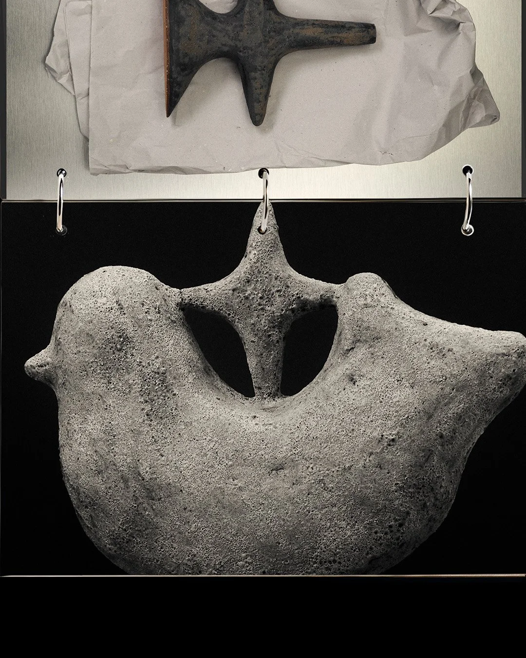 Scultura di pietra a forma di volto umano stilizzato, con ofrendo una faccia sorridente stereotipica.