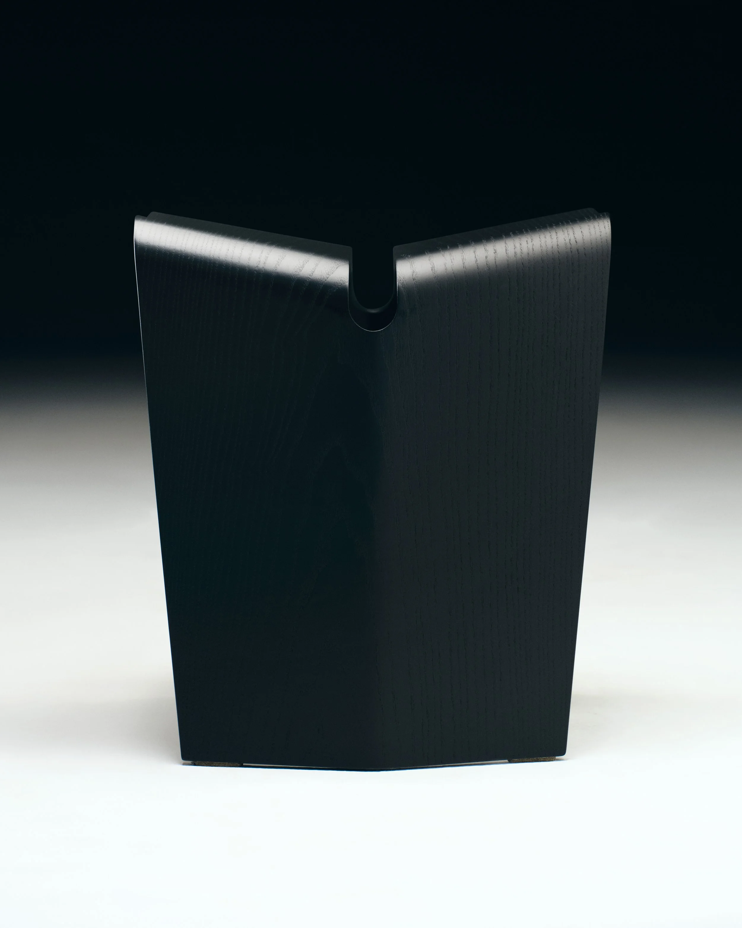 Un dispositivo elettronico nero, rotondo e con una scanalatura al centro, visibile su sfondo scuro con bordo illuminato.