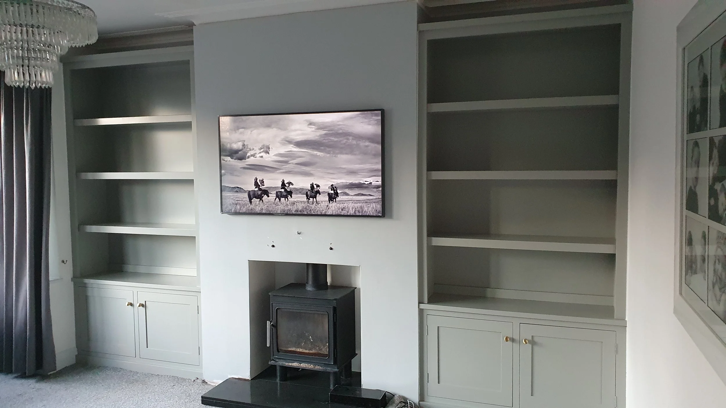 Painted Alcove units with shelving at the top and cupboards at the bottom fitted either side of a chimney breast. Fitted in Bedhampton